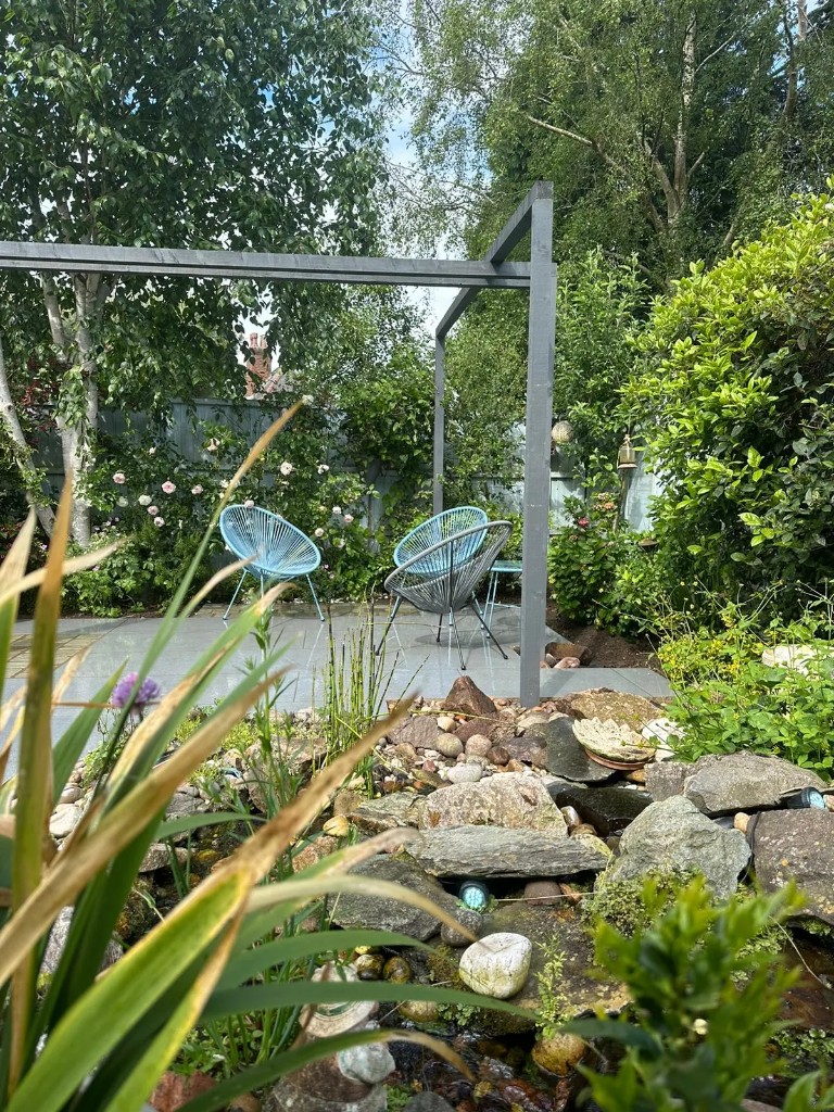 Grey patio, pergola seating and rockery planting in Jill Cottrell's garden