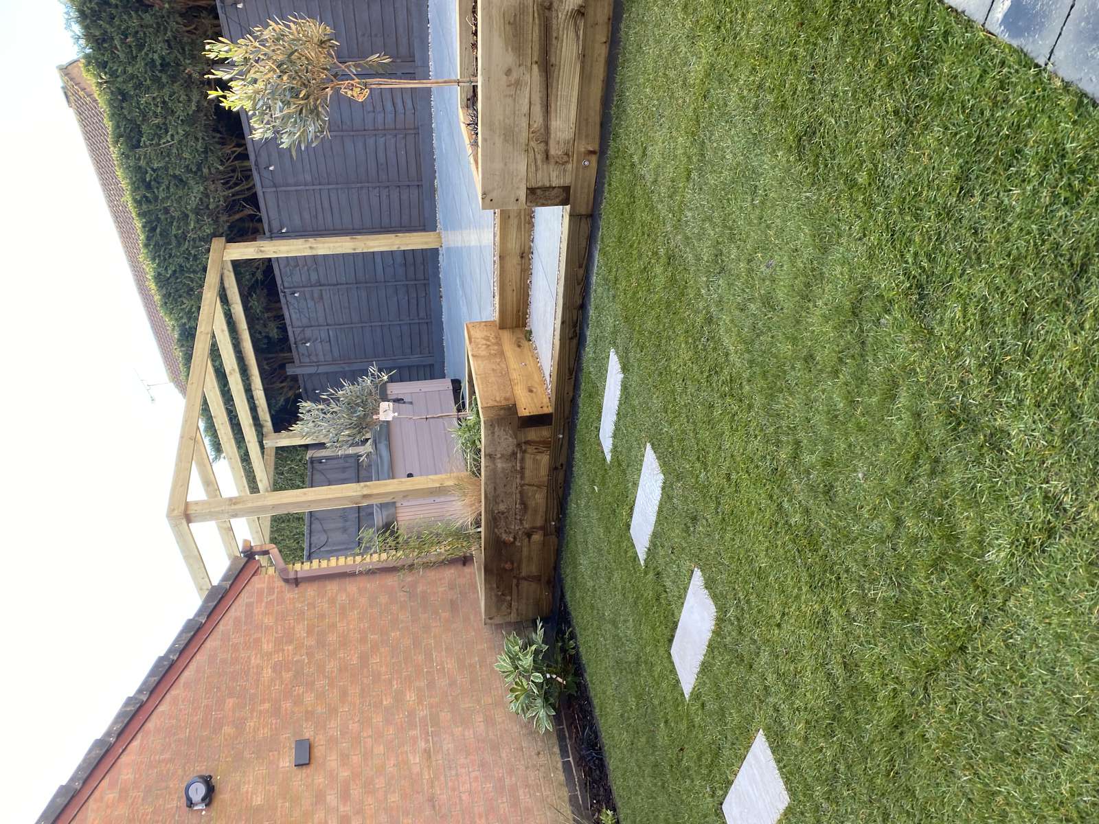 Modern Ratby garden featuring a porcelain patio, hot tub pergola and raised timber beds
