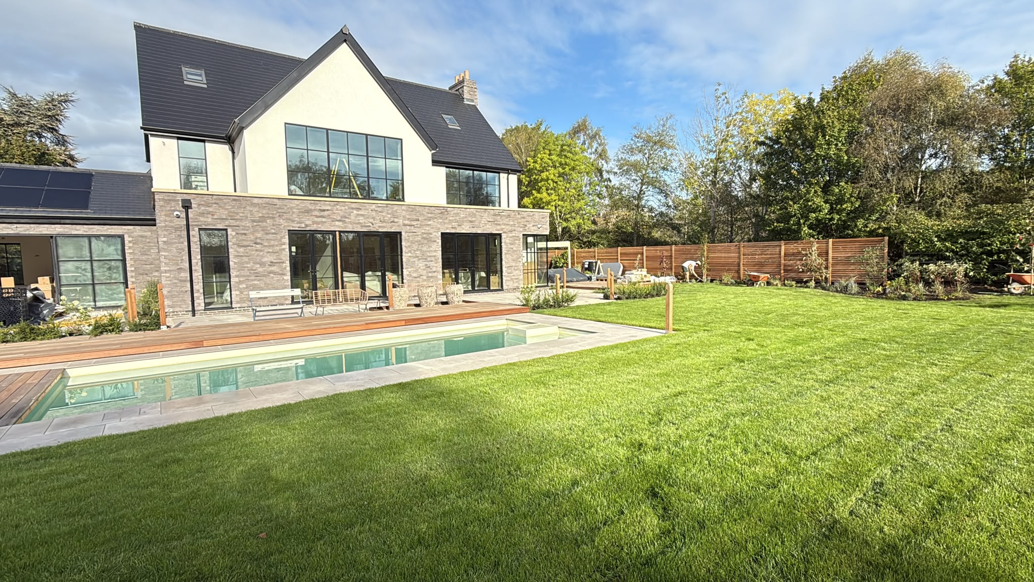 Rear of the Rothley house with pool terrace and lawn finishing