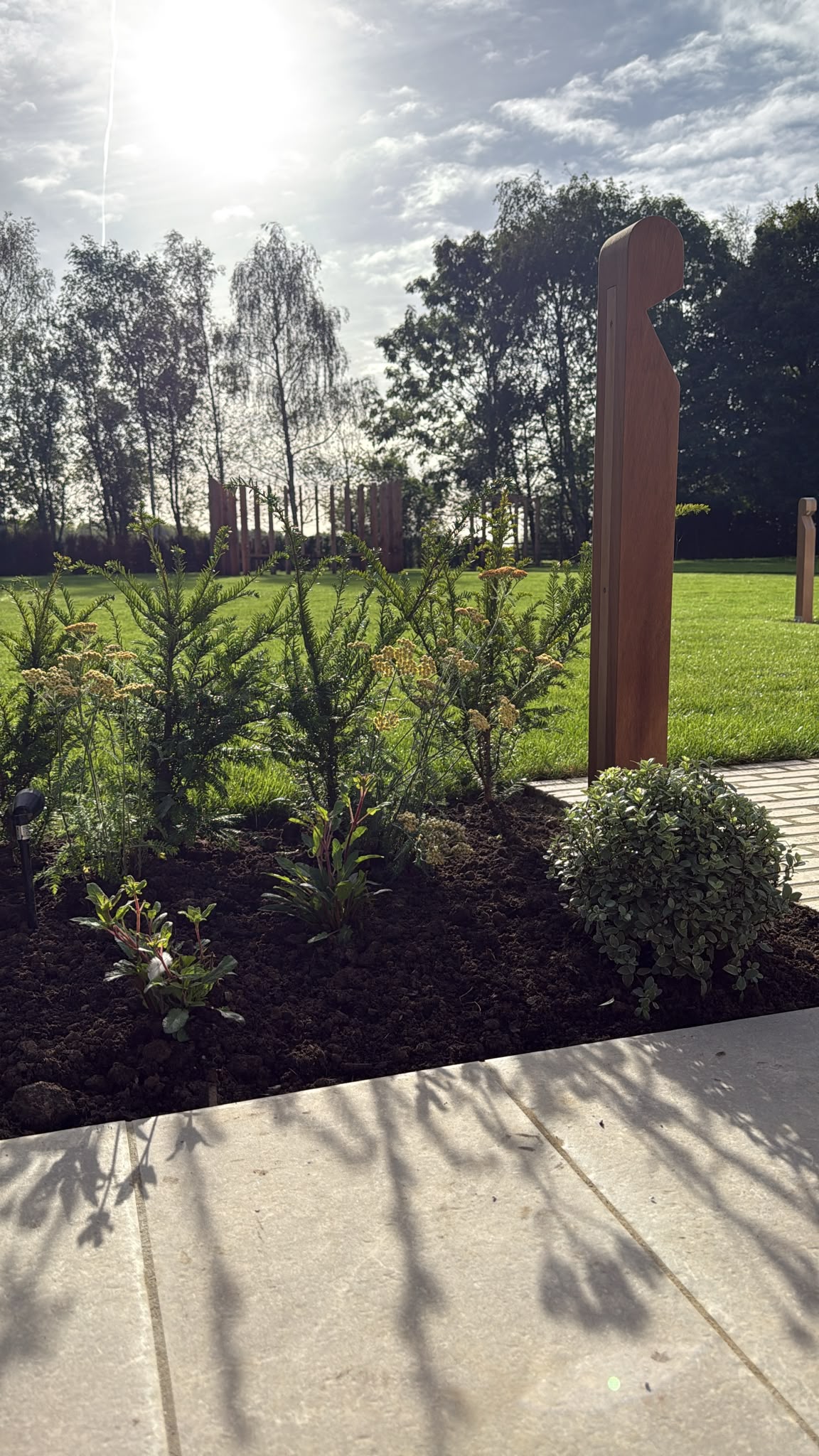 Freshly planted bed beside a timber post feature